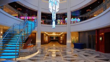 Im Herzen des Schiffes befindet sich der 678 Ocean Place. Über dem offenen Atrium schwebt ein eindrucksvoller Leuchter, dessen Farben beständig wechseln. Das Atrium erstreckt sich über die Decks 6 bis 8 © Melanie Kiel